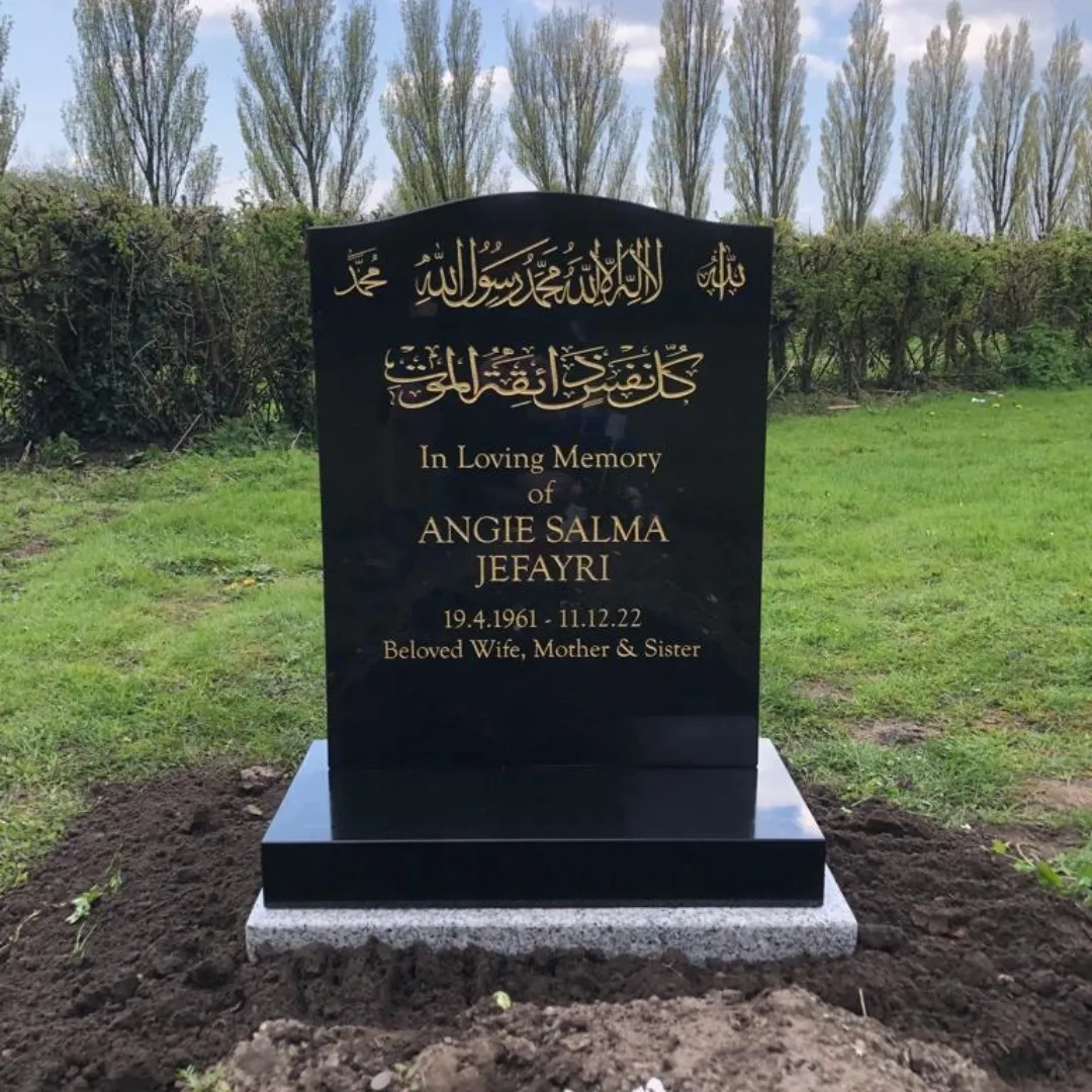 Polished black headstone with gold Arabic calligraphy and English lettering
